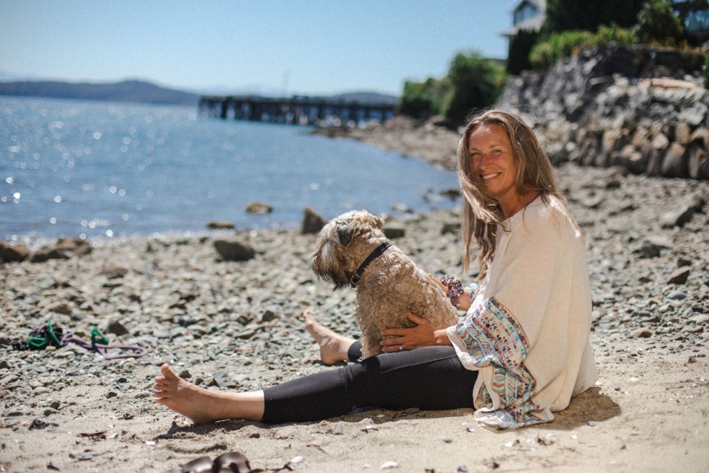 Livia sitting on beach with dog